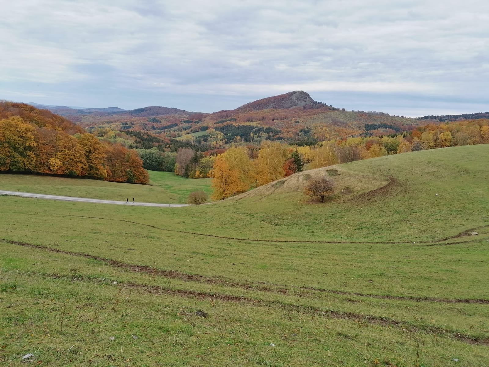 Herbstlicher Blick von der Maulkuppe über bunte Wälder auf den Felsgipfel der Milseburg